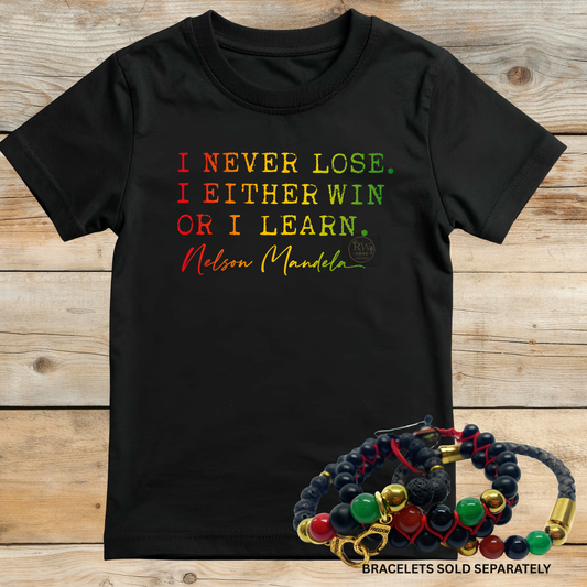 Black t-shirt with colorful text on a wooden surface, accompanied by a bracelet.
