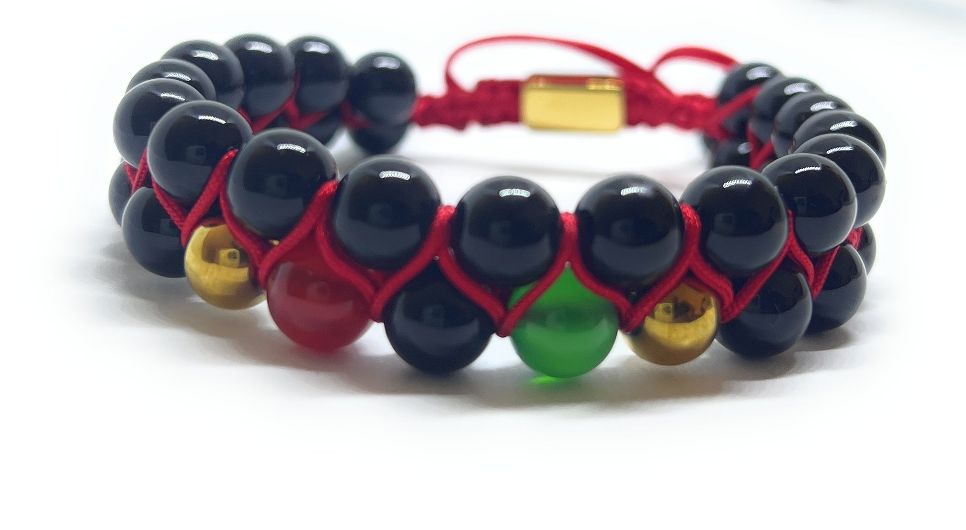 Beaded bracelet with black, red, and green beads on a white background