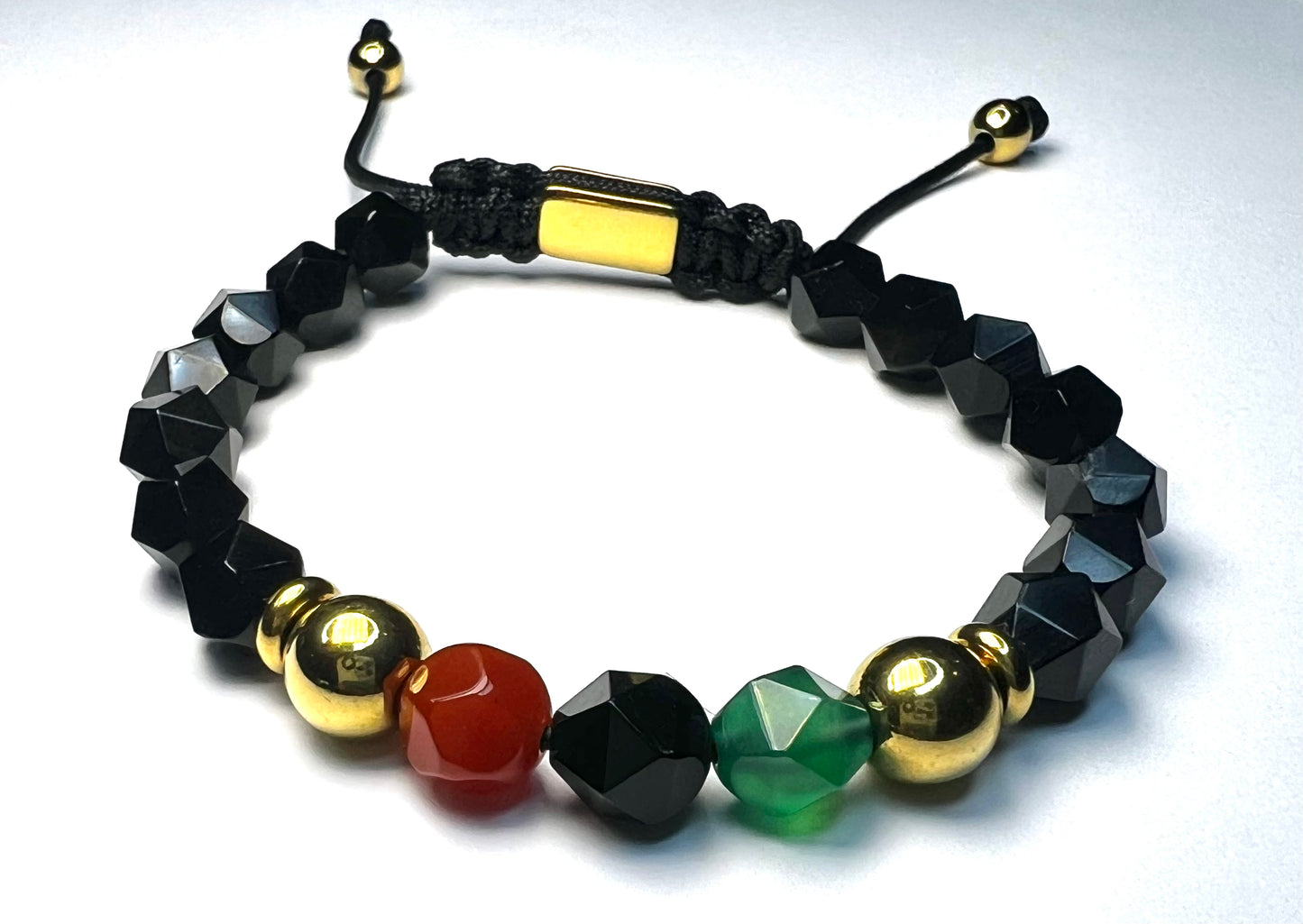 Multicolored beaded bracelet with black, gold, red, and green beads on a white background