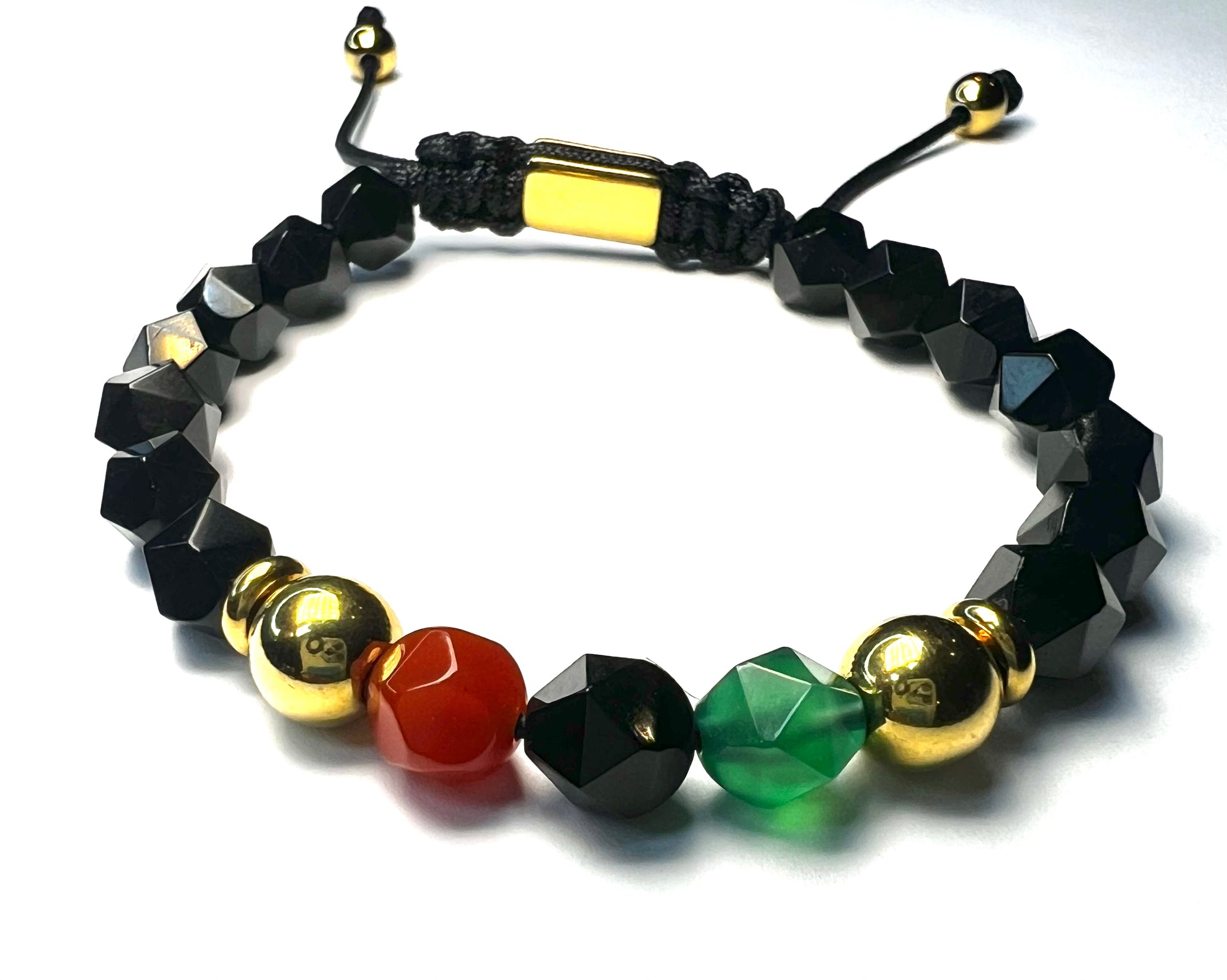 Bracelet with black, gold, red, and green beads on a white background