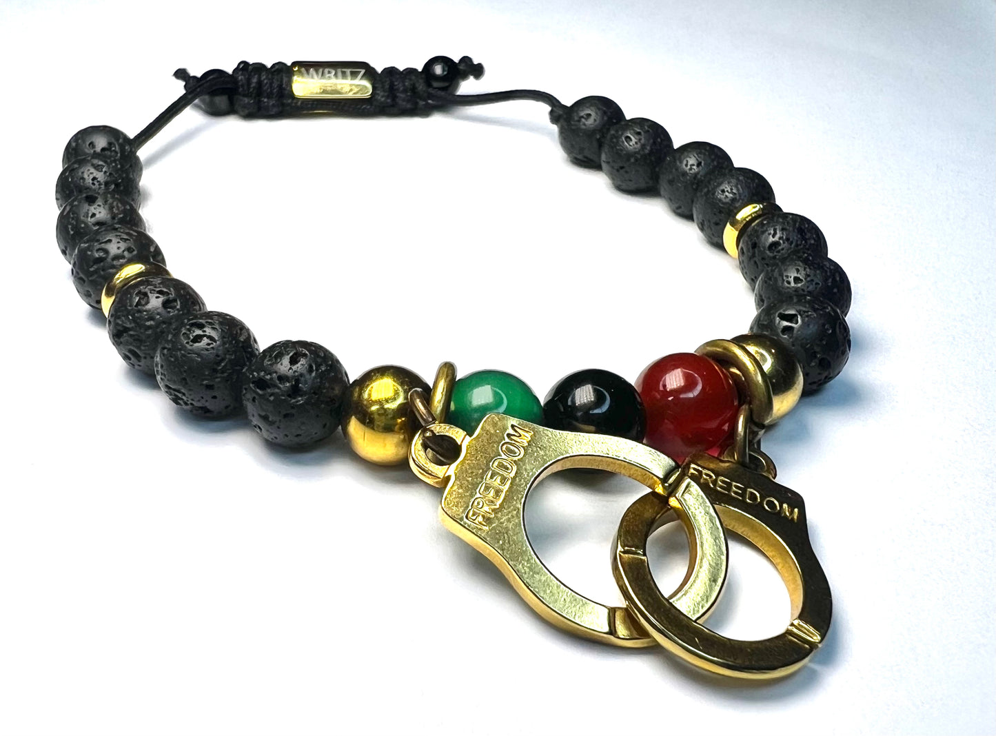 Bracelet with black beads, gold and red accents on a white background