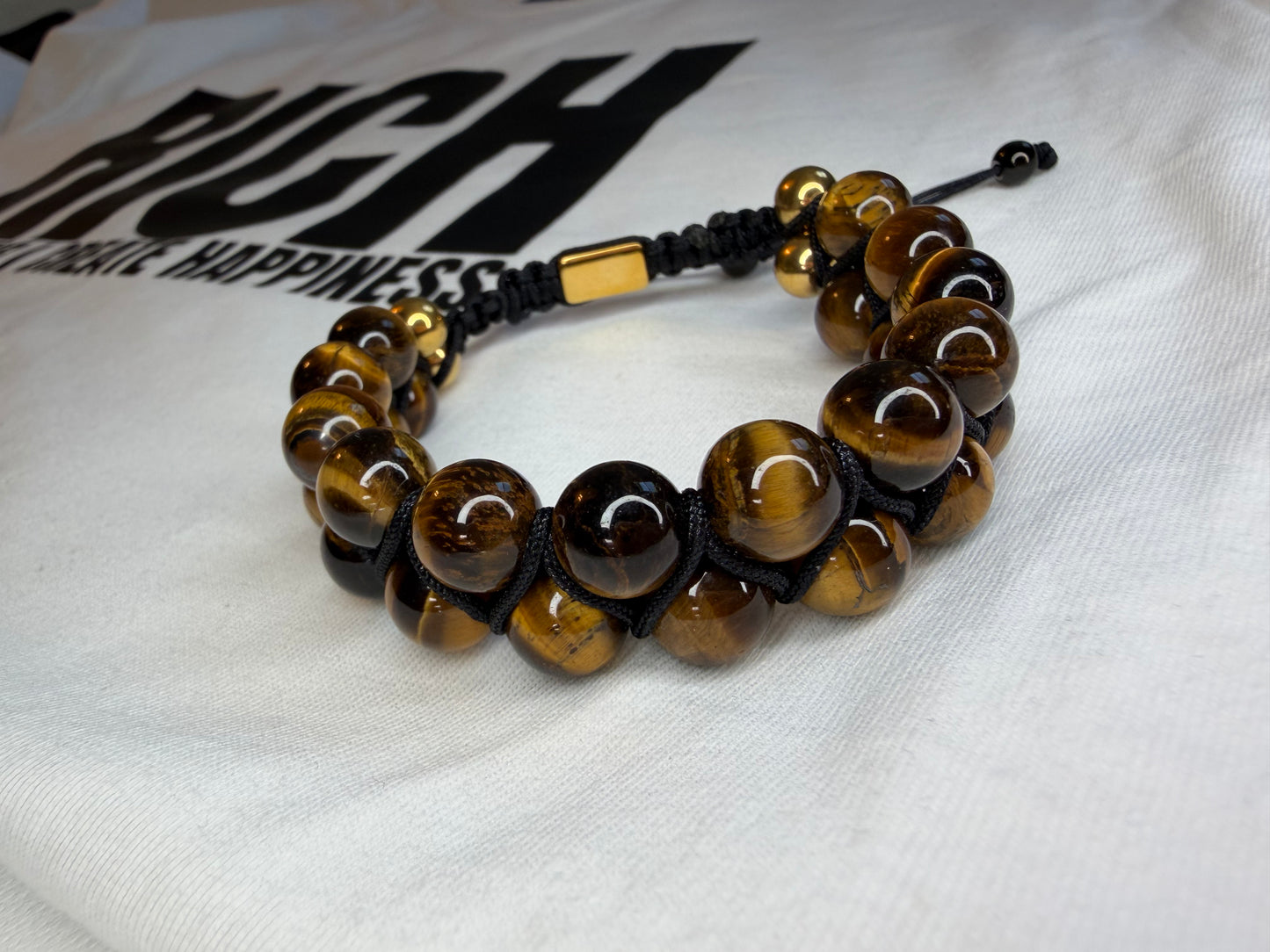 Beaded bracelet with gold accents on a white fabric background