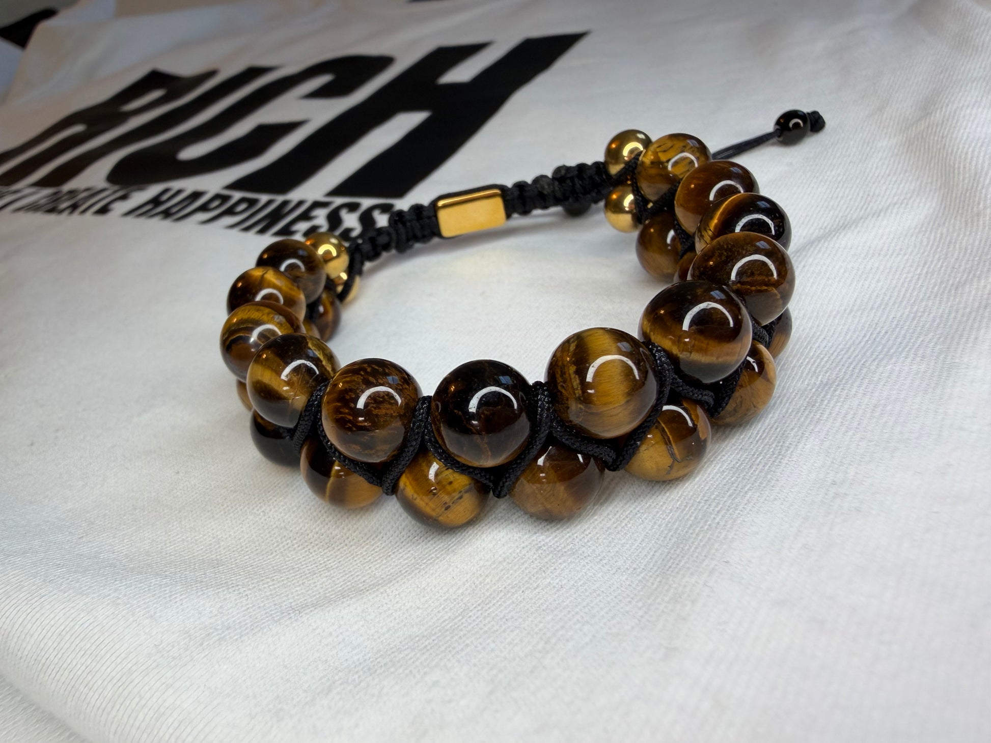 Beaded bracelet with gold accents on a white fabric background