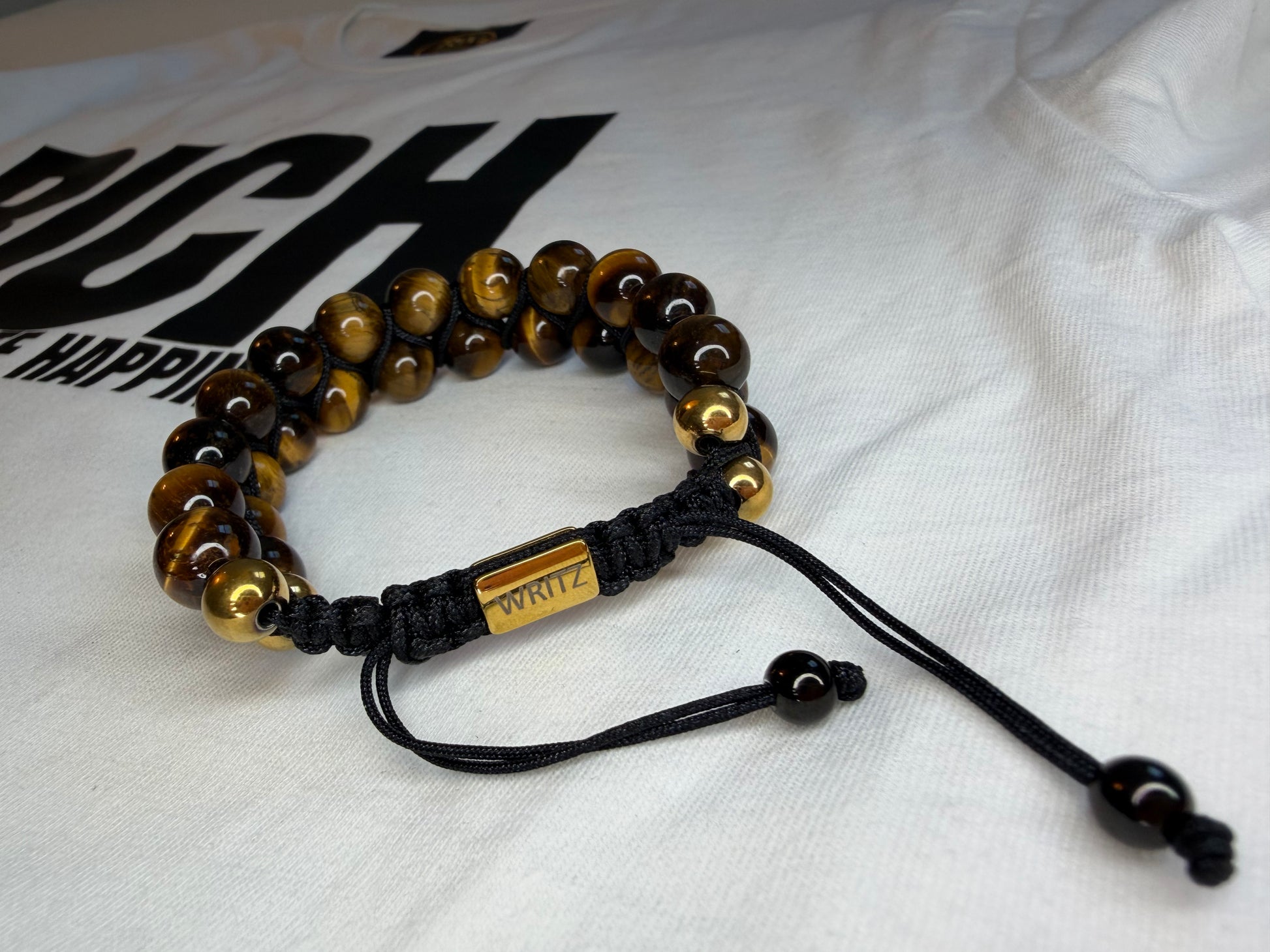 Bracelet with brown and gold beads on a white fabric background